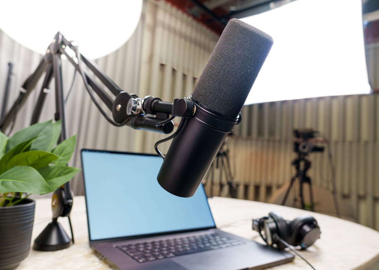 services-02 Professional podcast studio setup featuring a microphone, laptop, and headphones ready for recording.